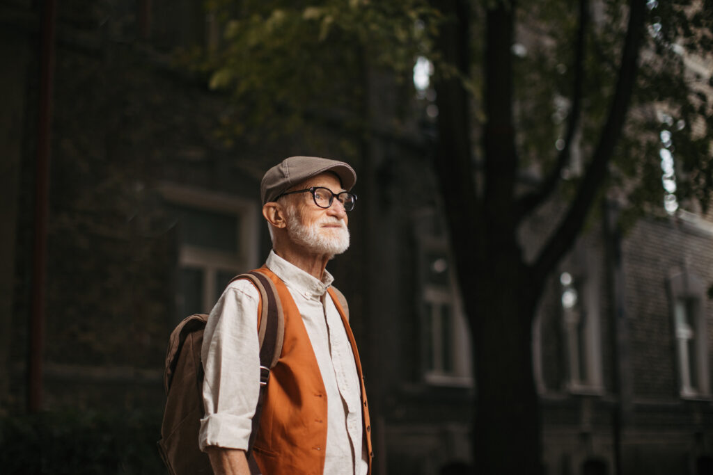 Senior tourist exploring new city, exploring interesting places. Elderly man with beret. Traveling